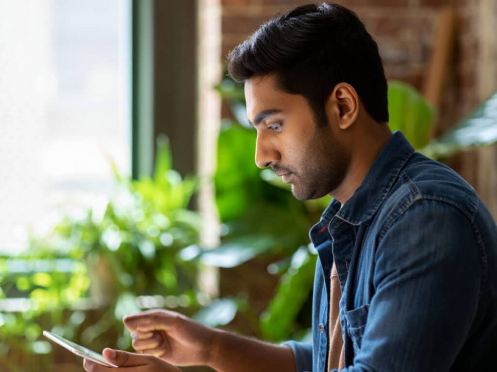 A man from an IT staffing agency looking at his phone.
