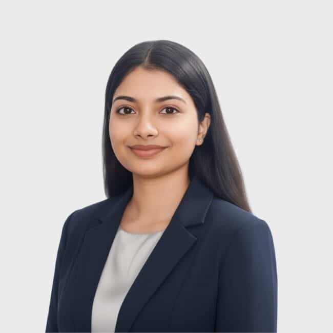A young woman with long dark hair wearing a navy blazer and white top, smiling slightly, poses against a plain light background—ideal for representing an IT staffing agency in Toronto.